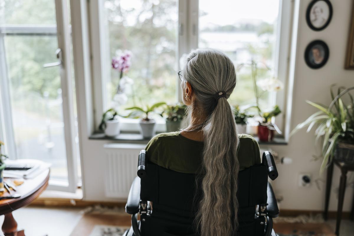 Mujer mayor de espaldas en su casa
