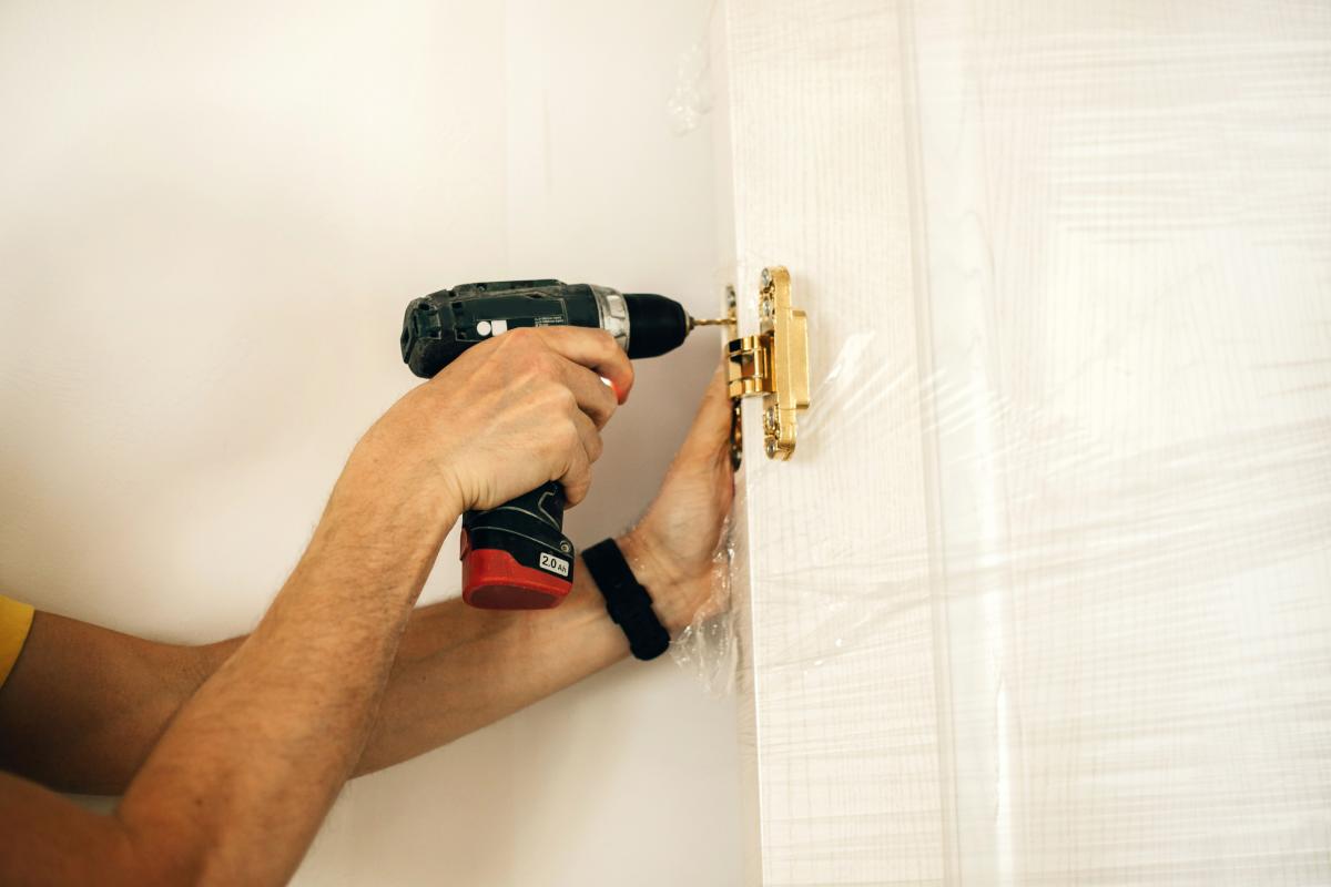 Un trabajador instalando una puerta, en una imagen de archivo