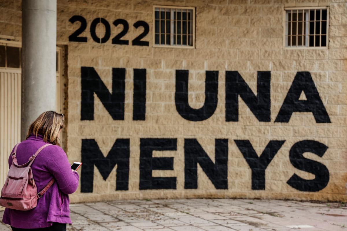Una mujer pasa junto a un muro que dice "Ni una menos", en Valencia, en 2022.