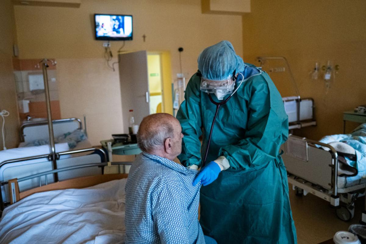 Un sanitario con equipo de protección asiste a un paciente infectado con COVID-19 en un área para ancianos en el Hospital de Bochnia (Polonia), el 7 de diciembre de 2021.