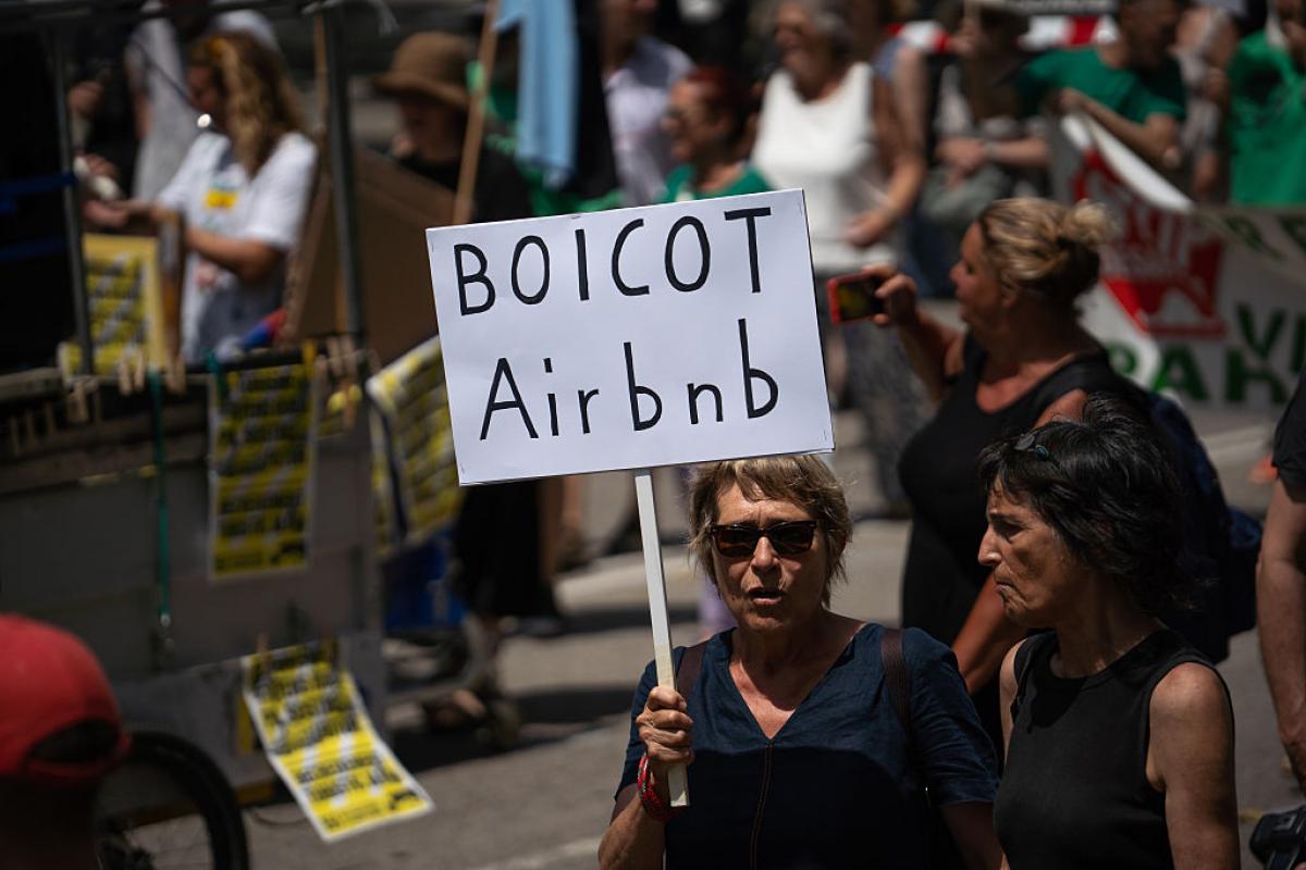 Un manifestante sostiene una pancarta que dice "Boicot Airbnb" durante una manifestación antiturismo en Barcelona, el 15 de junio de 2025.