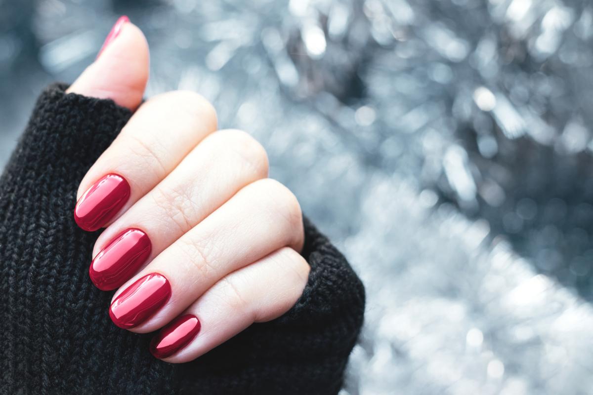 Una mujer enseña su manicura navideña