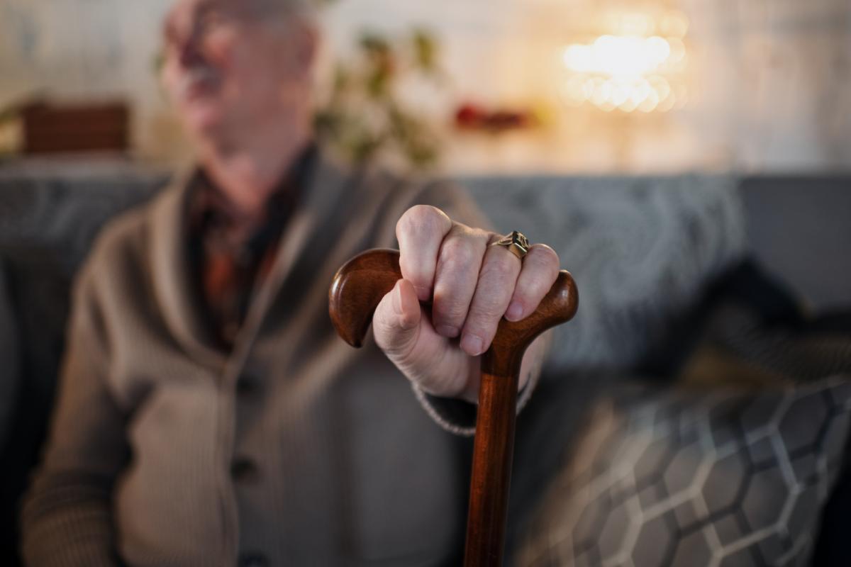 Un anciano sujetando un bastón, en una imagen de archivo