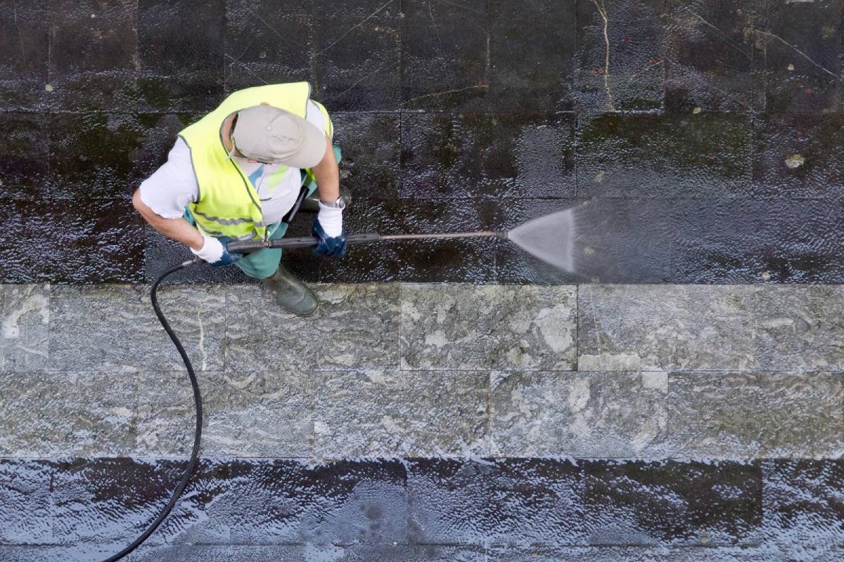 Operario limpiando las calles con agua a presión