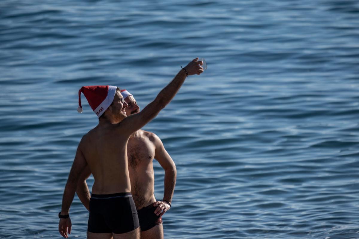 Dos hombres se hacen un selfi en la playa de la Barceloneta, en Barcelona, el invierno pasado.