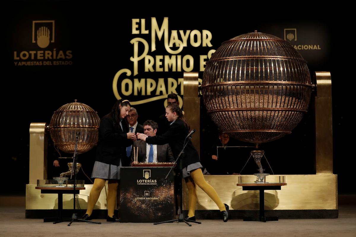 Niñas toman una pelota con números durante la Lotería de Navidad española 'El Gordo' en la Casa Real de la Ópera de Madrid en Madrid, España, el 22 de diciembre de 2018.