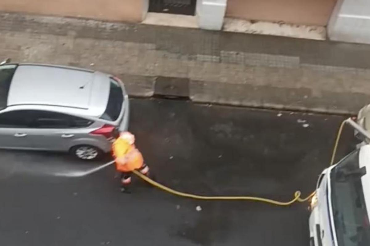 Operario de limpieza urbana en España usando una manguera
