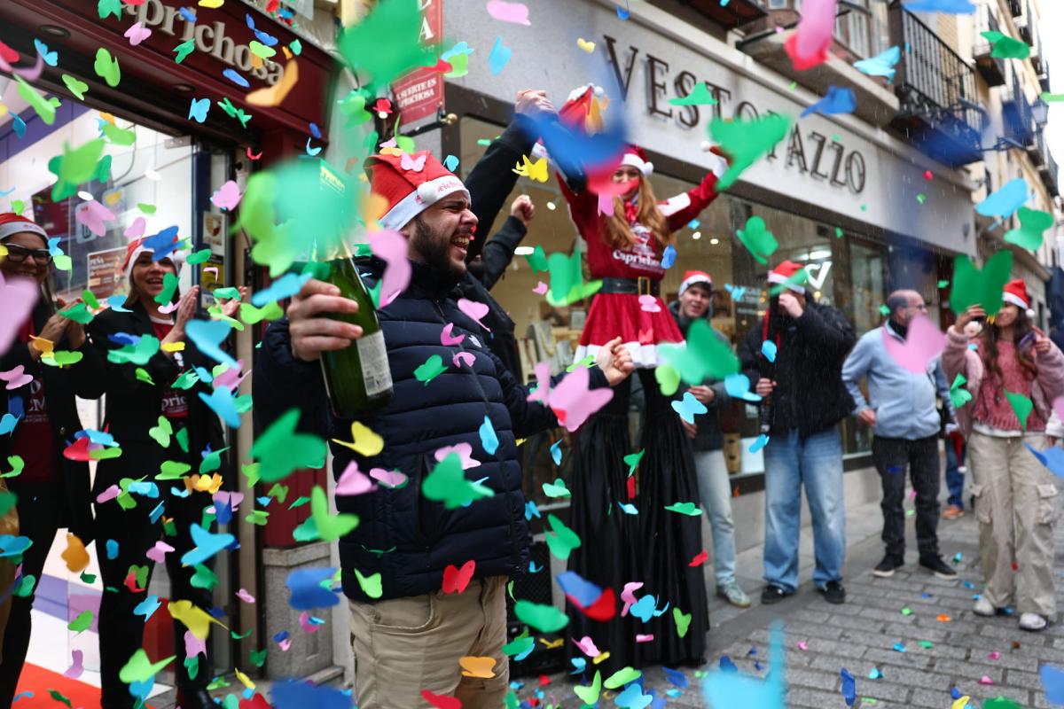 Varias personas celebran a las puertas de una administración de lotería este lunes en Toledo, donde se ha vendido el número 78.477, que ha sido agraciado con un cuarto premio en el Sorteo de la Lotería de Navidad y dotado con 200.000 euros a la serie (20.000 euros al décimo).