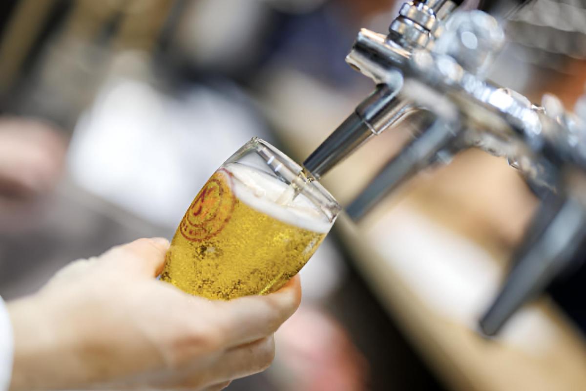 Un camarero tirando una caña de cerveza en un bar