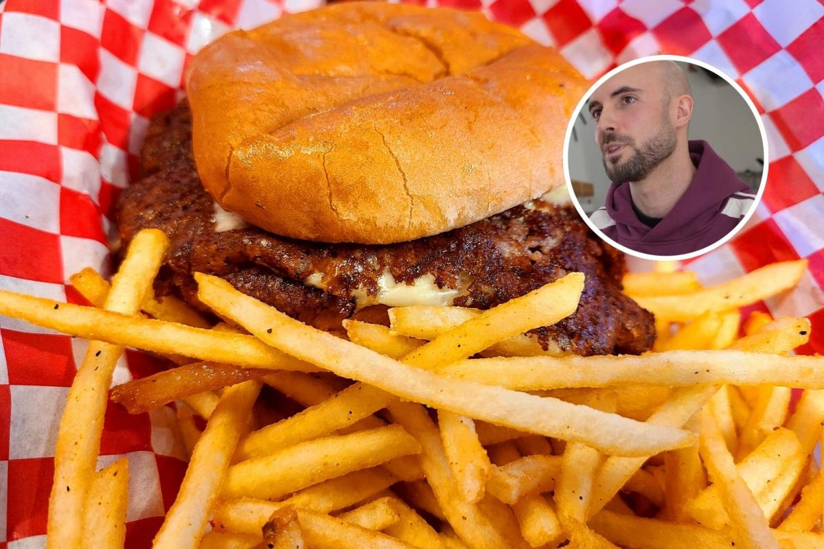 Enric, dueño de la hamburguesería, con un smash burger de fondo.