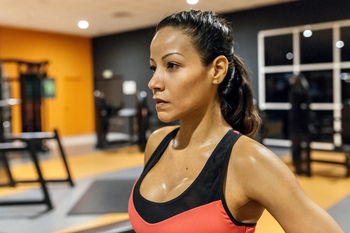 Retrato de una mujer transpirando después de entrenar en el gimnasio