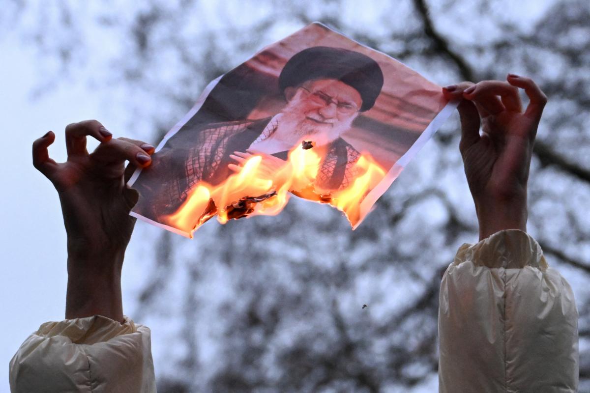 Una manifestante sostiene una foto en llamas del líder supremo de Irán, el ayatolá Ali Khamenei, durante una protesta en apoyo al pueblo iraní frente a Downing Street, en Londres, el 11 de enero de 2026.