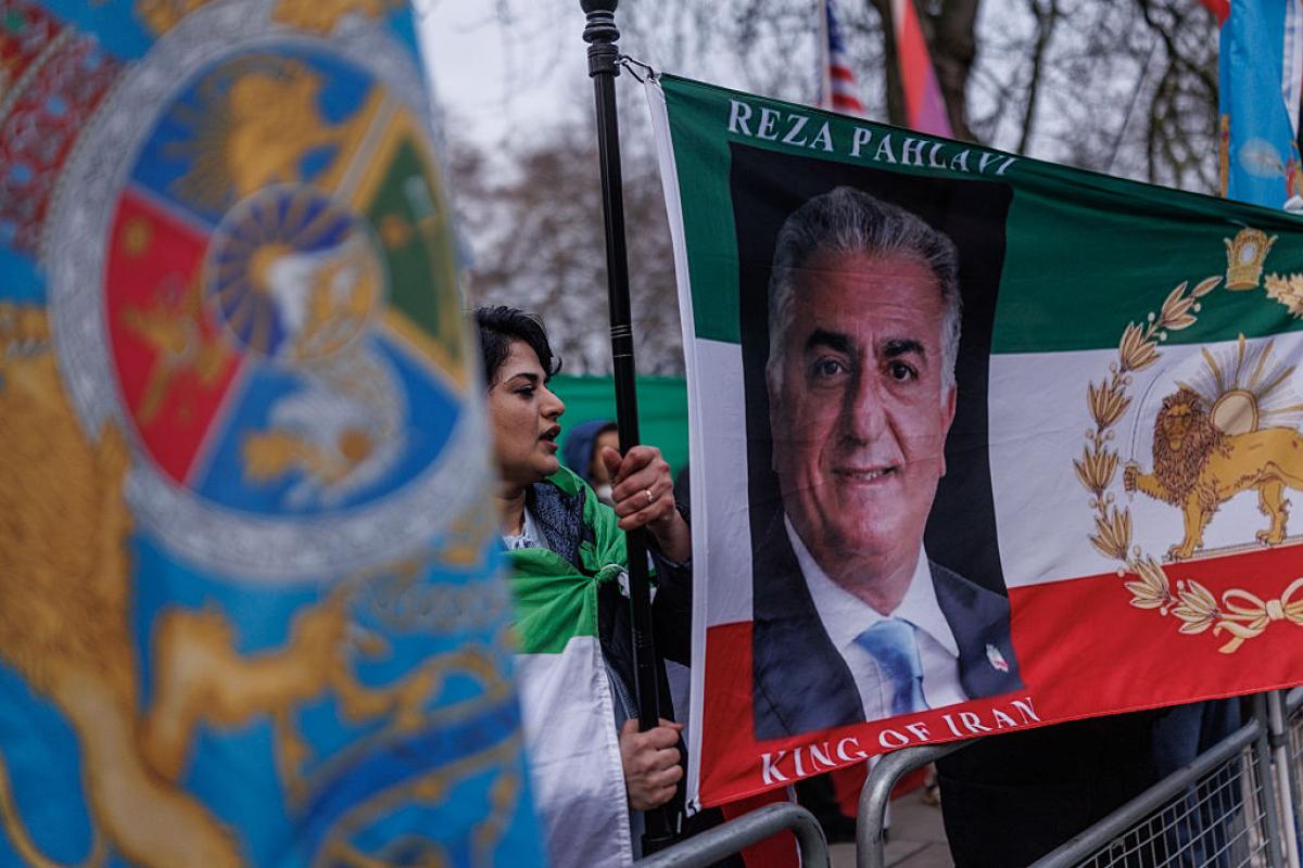 Manifestantes ondean banderas que del príncipe heredero iraní en el exilio, Reza Pahlavi, frente a la Embajada de Irán, el 14 de enero de 2026, en Londres, (Reino Unido).