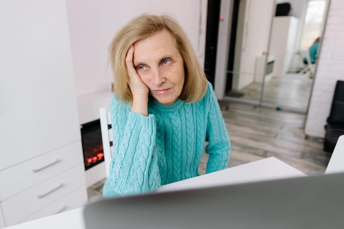 Una pensionista mayor revisa documentación relacionada con prestaciones de jubilación.