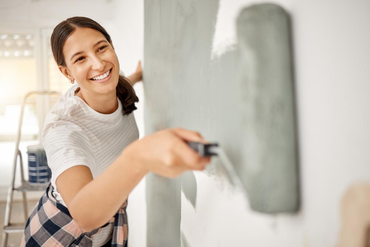 Joven pintando la pared de una casa, en una imagen de archivo.