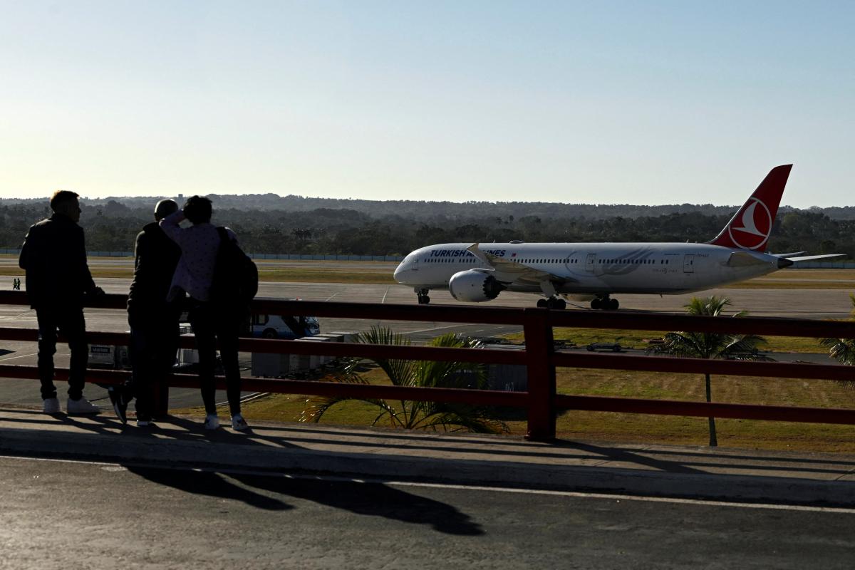 Unos cubanos observan un avión de Turkish Airlines en el Aeropuerto Internacional José Martí de La Habana, el 9 de febrero de 2026.