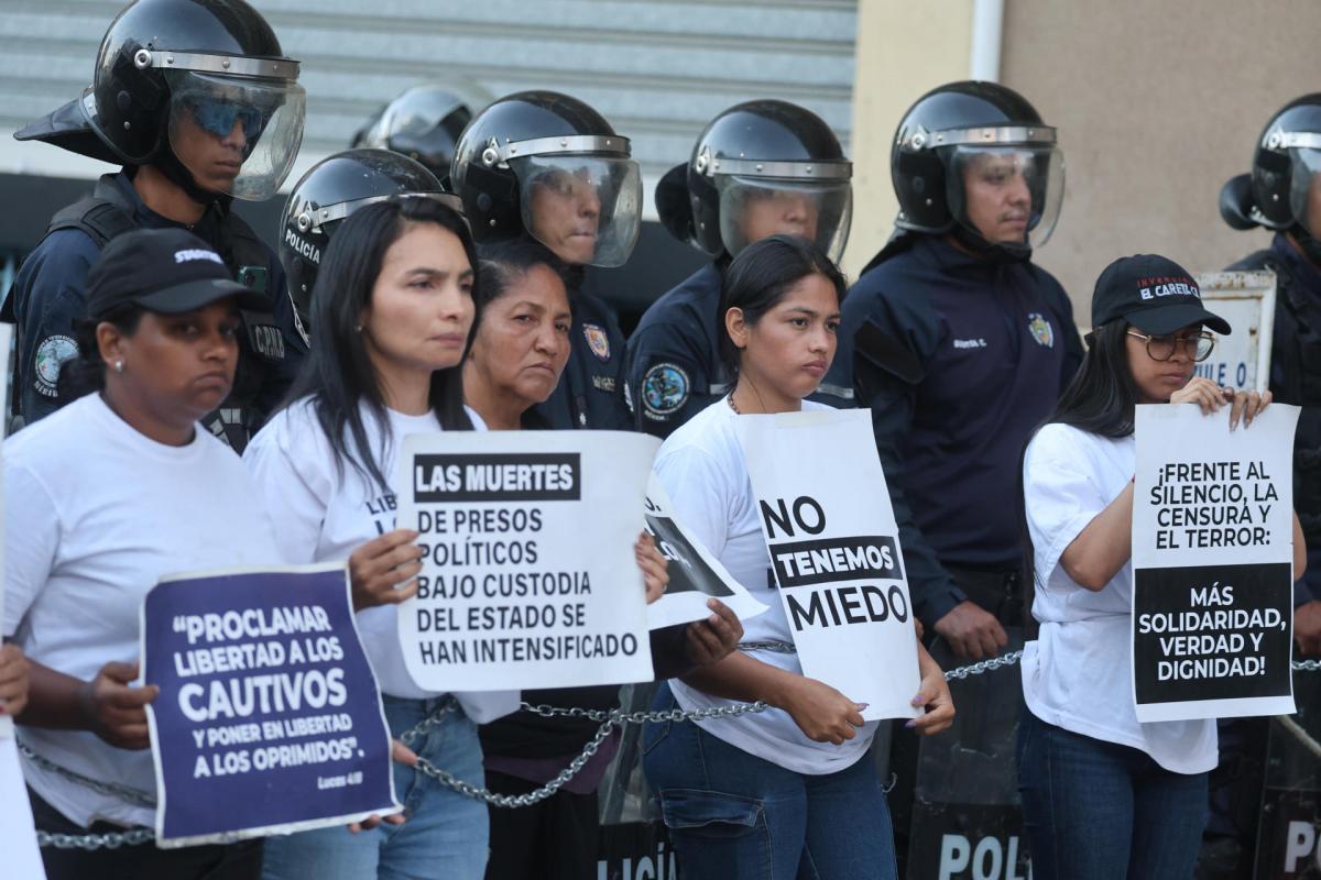 Familiares de presos políticos sostienen carteles durante una vigilia frente a la Zona 7 este jueves, en Caracas (Venezuela).