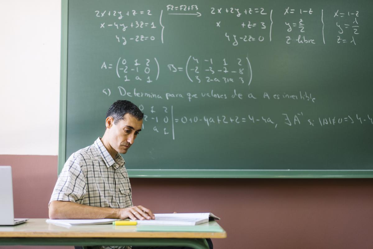Un profesor leyendo un libro en el aula de clase.