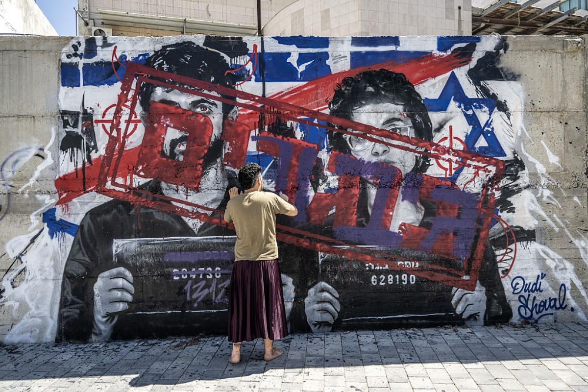 Un hombre pinta con spray un mural contra Yuval Abraham y Rachel Szor, directores de 'NAZA', el 16 de septiembre de 2026, en Ashdod (Israel).