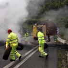 Un grupo de operarios retira los neumáticos incendiados en los túneles del Padrún, en la A-66.