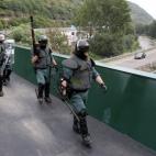 Agentes de la Guardia Civil caminan por un puente encima de la carretera A66, después de restablecer el tráfico cortado por una barricada
