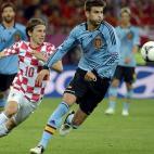 Piqué trata de evitar que Modric (izquierda) gane el balón.