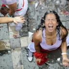 Una mujer disfruta del agua durante el chupinazo.
