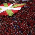 Cientos de pañuelos rojos, junto a una ikurriña.