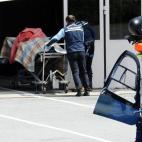 En la imagen, dos operarios trasladan el cuerpo de uno de los fallecidos.