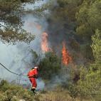 Dos miembros de la Unidad Militar de Emergencias se acercan hasta uno de los focos que afecta a localidad de Carlet, en la Comunitat Valenciana