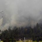 Un helicóptero arroja agua sobre el incendio que se inició el pasado domingo en una zona de huertas del municipio de Vilaflor, y que hoy ha entrado en La Orotava y en el Parque Nacional del Teide