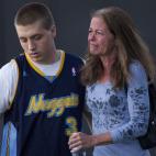 Eyewitness Jacob Stevens, 18, hugs his mother Tammi Stevens after being interview by police outside Gateway High School where witnesses were brought for questioning Friday, July 20, 2012 in Aurora, Colo. A gunman wearing a gas mask set off an ...