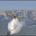 Un hidroavión lanza agua sobre un bosque de Boadella este mediodía para apagar el incendio