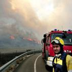 Un efectivo del cuerpo de bomberos observa en la AP-7 las llamas del incendio.
