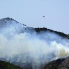 Un helicóptero sobrevuela la tierra incendiada
