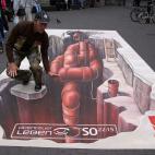 El pintor callejero posa con su obra en Dusseldorf, Alemania