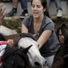 Una mujer, rodeada de caballos.