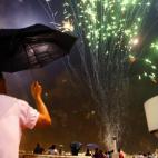 Vecinos de Elche siguen desde una azotea el espectáculo pirotécnico que se celebra en la tradicional Nit d'Albà, con motivo de las fiestas en honor a la Virgen de la Asunción.