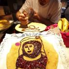 Un pastelero decora una crepe. Es en el Horno de San Onofre ubicado, en el madrileño mercado de San Miguel.