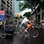 Un manifestante lleva una bandera nacional al revés frente a un grupo de policías antidisturbios
