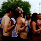 Manifestantes permanecen bajo un aguacero producto de la tormenta Isaac cerca de la Convención Nacional Republicana