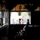 Manifestantes pasan frente a una ventana de un restaurante donde un grupo de líderes republicanos está reunido