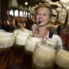 Una mujer, cargada con jarras de cervezas