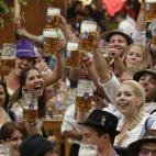 Varios asistentes levantan sus jarras