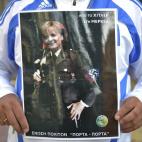 Un hombre sujeta una pancarta hoy en la que se puede leer 'De Hitler a Merkel' frente a la embajada alemana en Atenas, Grecia.