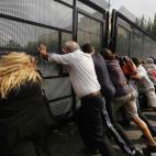 Manifestantes contra una barricada puesta por la policía.