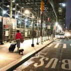 Una mujer, con su maleta, rumbo a la estación de Wall Street para abandonar la ciudad ante la alerta por Sandy.