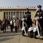 Policías chinos hacen guardia sobre vehículos eléctricos frente al Gran palacio del Pueblo