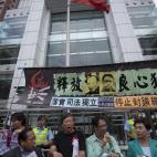 Activistas prodemocráticos rompen fotos del XVIII Congreso del Partido Comunista de China mientras protestas en los alrededores de la Delegación del Gobierno chino en Hong Kong