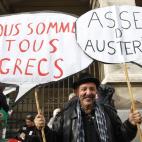 Worker holds placards reading " , We are all Greek, enough austerity" , during a demonstration against austerity, in Marseille, southern France, Wednesday, Nov. 14, 2012. With rampant unemployment spreading misery in southern Europe and companie...